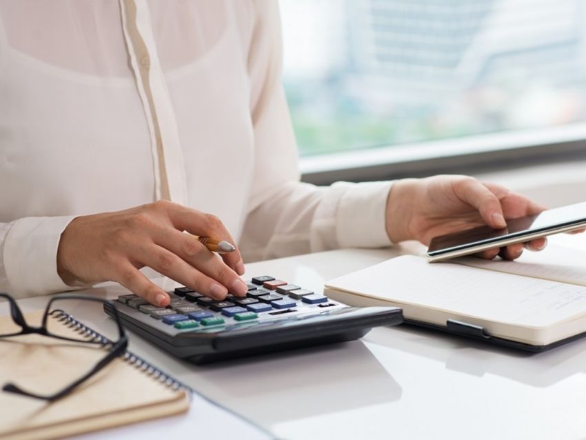 closeup of woman using calculator and smart phone